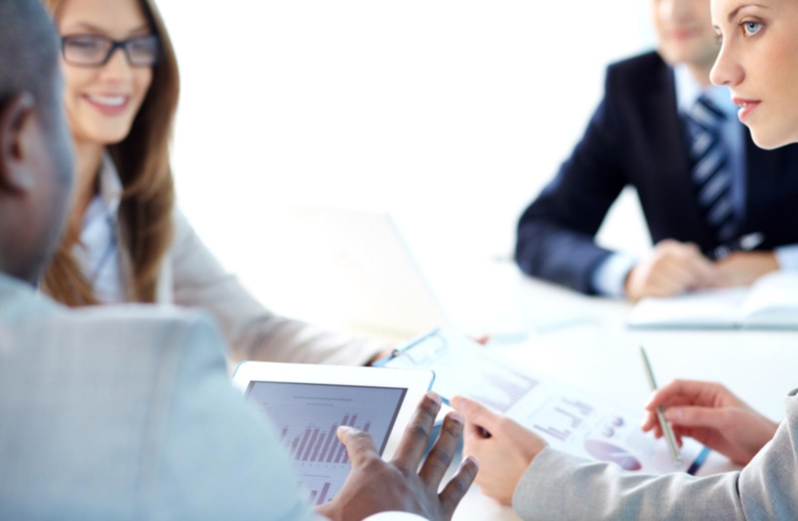 Professional discussing financial concepts with analytical charts in background